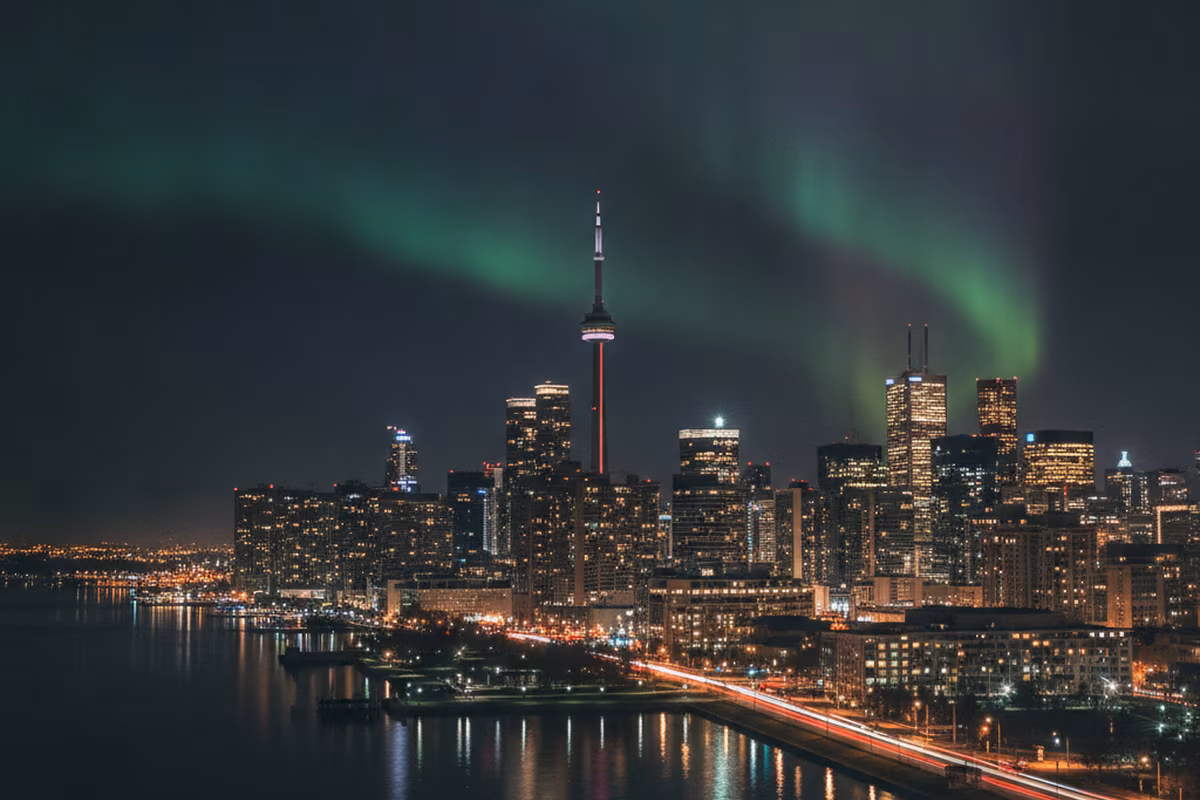 Toronto skyline at night with a faint aurora above the financial district